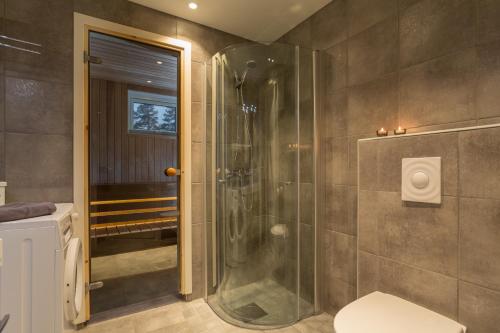 a bathroom with a shower and a toilet at GLØD Boutique Apartment in Alta