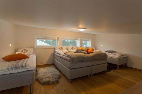 a room with two beds and a couch and two windows at GLØD Boutique Apartment in Alta
