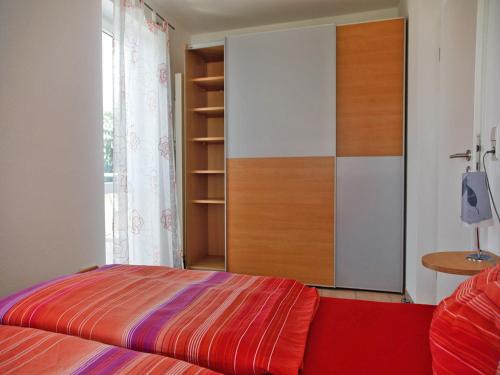 een slaapkamer met een bed en een kast bij Ferienwohnung Amann in Nonnenhorn
