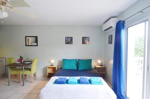 Un dormitorio con una cama con almohadas azules y una mesa. en Pelican Pearl, en Simpson Bay