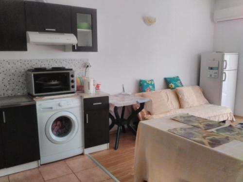 a living room with a washing machine and a couch at Sea Apartment in Burgas