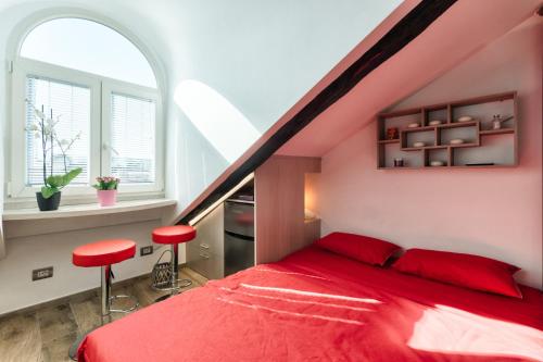 a bedroom with a red bed and two red stools at Multifunctional Stylish Studio in Turin