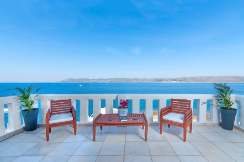 two chairs and a table on a balcony with the ocean at Cape Villa at Sounio in Sounio