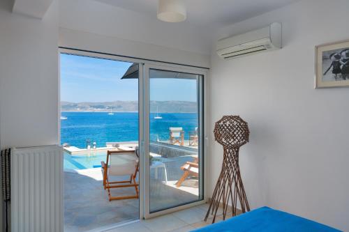 a room with a balcony with a view of the ocean at Cape Villa at Sounio in Sounio