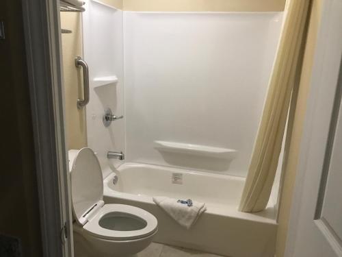 a small bathroom with a toilet and a bath tub at Knights Inn Lumberton in Lumberton