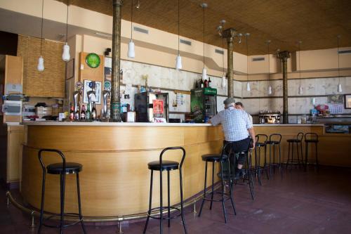 a man standing at a bar in a restaurant at Tirso de Molina in Almazán
