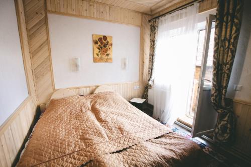 a bedroom with a bed in a room with a window at Skarbivka in Vorokhta