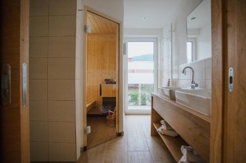 a bathroom with two sinks and a large window at Apartmenthaus Strasswirt De Luxe in Tröpolach