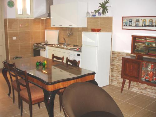 レッジョ・ディ・カラブリアにあるCasa Zerbiのキッチン(テーブル、白い冷蔵庫付)