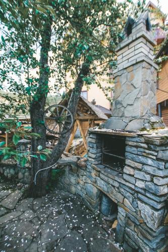 a stone oven in a yard with a tree at Skarbivka in Vorokhta