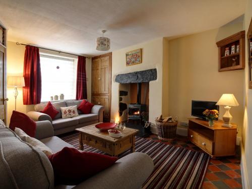 ランウストにあるBryn Ffynnon Holiday Cottage Llanrwstのリビングルーム(ソファ、テーブル付)