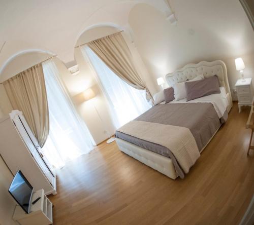 シエナにあるPalazzo de' Vecchiのベッドルーム1室(大型ベッド1台、窓2つ付)