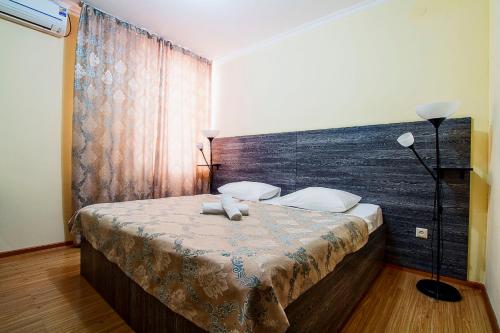 a bedroom with a large bed with a wooden headboard at Bereket in Astana