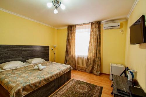 a bedroom with a bed and a large window at Bereket in Astana