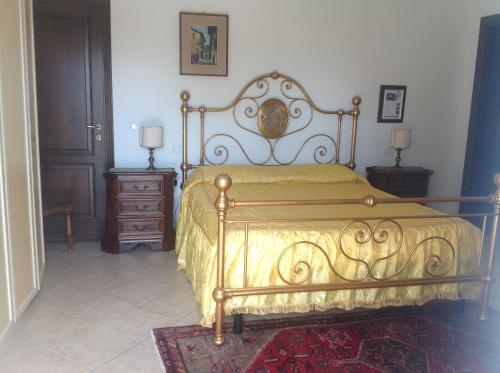 een slaapkamer met een bed met een gele sprei bij Villa Trieste in Albinia