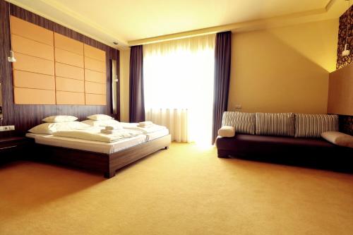 a bedroom with two beds and a large window at Ipari Park Panzió in Szolnok