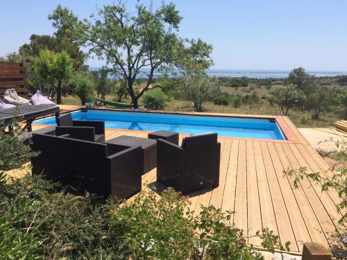 une piscine avec une terrasse en bois et une piscine dans l'établissement La bergerie du chateau de Fitou, à Fitou