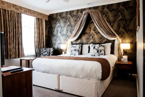 1 dormitorio con 1 cama grande con dosel en The Mad Hatter Hotel en Londres