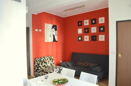 a living room with orange walls and a couch at Taormina For You in Taormina