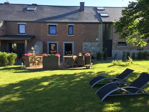 une maison avec des chaises et une table dans la cour dans l'établissement B&B Au Coeur de Villers, à Villers-Sainte-Gertrude