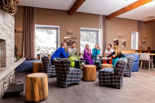 people sitting around a living room at Horsky Hotel Sliezsky Dom in Vysoké Tatry