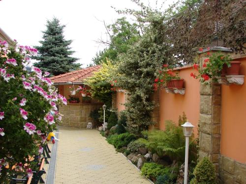 a garden with pink flowers and a pathway at Penzión KORMOŠ in Štúrovo