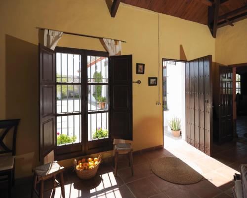 a room with doors and a bowl of fruit on a table at Reservaloen Hacienda las Marciagas in Benacazón