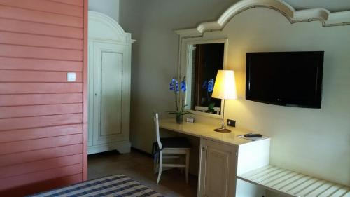 a bedroom with a desk with a tv on a wall at Motel 7 Laghi in Castelletto di Branduzzo