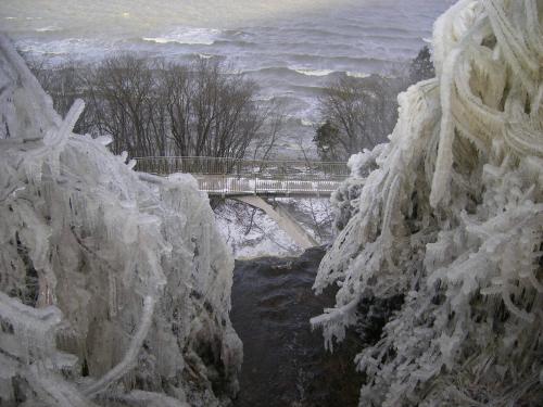 a bridge over a river covered in ice and snow at Valaste Puhkeküla in Kohtla-Järve