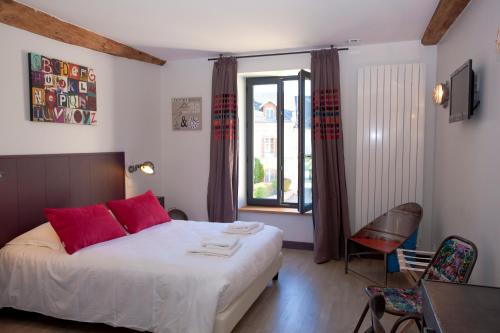 Schlafzimmer mit einem Bett mit roten Kissen und einem Fenster in der Unterkunft Les Tournelles - Chambres d'hôtes in Saint-Mesmes