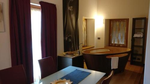 a bathroom with a tub and a table with chairs at Marco Polo in Vittorio Veneto