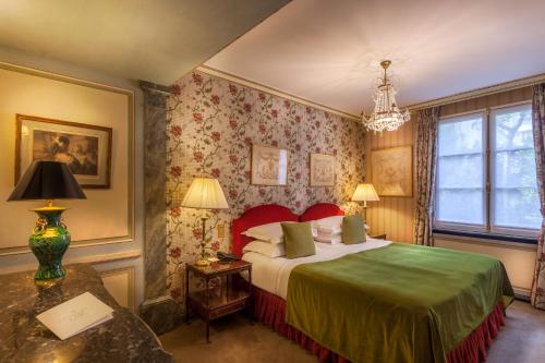 1 dormitorio con 1 cama y 1 mesa con lámpara en Hôtel Duc De St-Simon en París