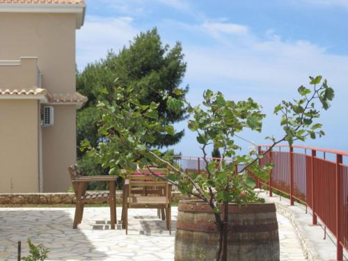 a bench and trees in front of a fence at Sun Gazing Villas in Drymon