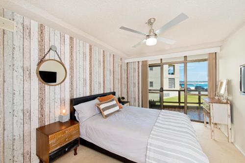 - une chambre avec un lit, un miroir et une fenêtre dans l'établissement Beauty at the Beach - modern beachfront apartment, à Port Macquarie