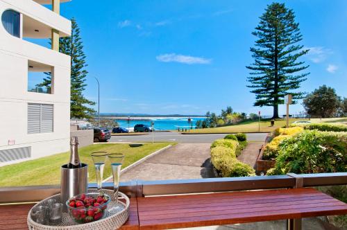 a bowl of fruit sitting on a table on a balcony at Beauty at the Beach - modern beachfront apartment in Port Macquarie