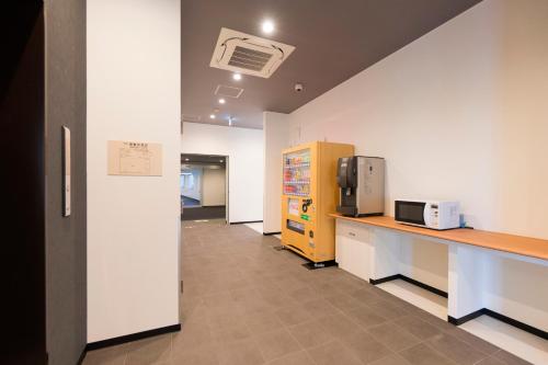 an office hallway with a counter and a microwave at Mikasa Tennen Onsen Taikonoyu Sparesort Hotel Taiko Bettei Hatago in Iwamizawa
