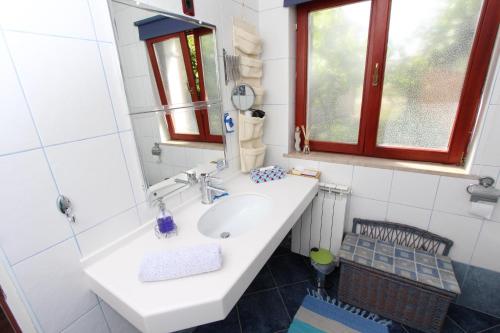a bathroom with a white sink and a mirror at Apartments Villa Nikola in Rovinj
