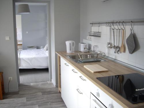 a kitchen with a counter and a room with a bed at Apt 8 du Temple HyperCentre & Parking in Cambrai
