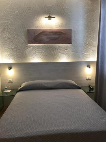 a hotel room with a bed and a lamp at NovaHotel in Reggio Emilia