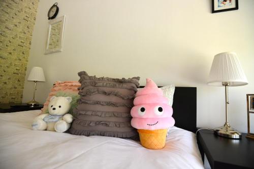a bed with two stuffed animals and an ice cream cone at Hotel Biscuit in Cluj-Napoca