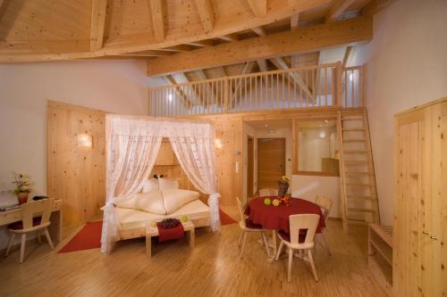 a bedroom with a bed and a table and a ladder at Residence Garni Alpenstern in Resia