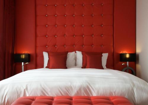 a bedroom with a large bed with a red headboard at Bermondsey Square Hotel - A Bespoke Hotel in London