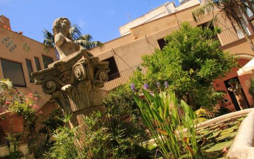 a statue of a woman on a fence in front of a building at Antica Corte delle Ninfee, Historical Private Villa in Trapani