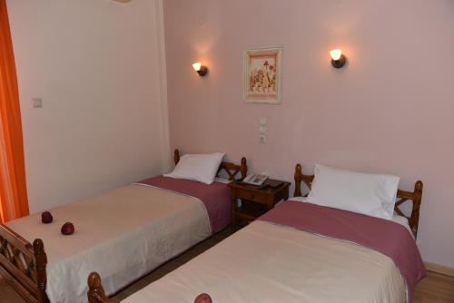 ルトラ・エディプソスにある40 Platania Hotelのベッド2台、テーブル、電話が備わる客室です。