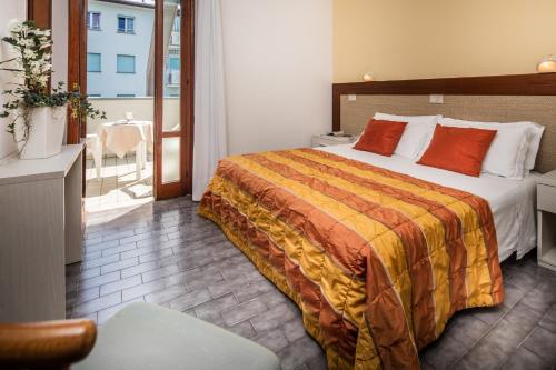 um quarto de hotel com uma cama e uma varanda em Hotel Bettina em Lido di Jesolo