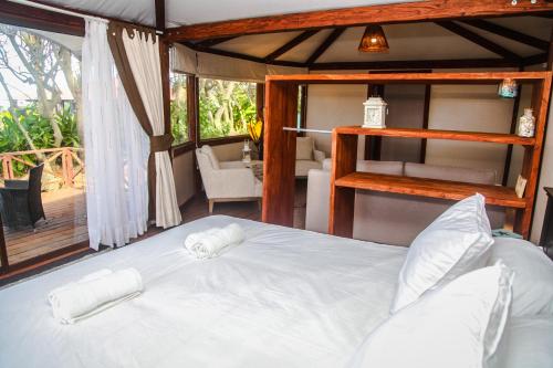 a bedroom with a bed with two towels on it at Vaihu Nui Bungalow-Glamping in Hanga Roa