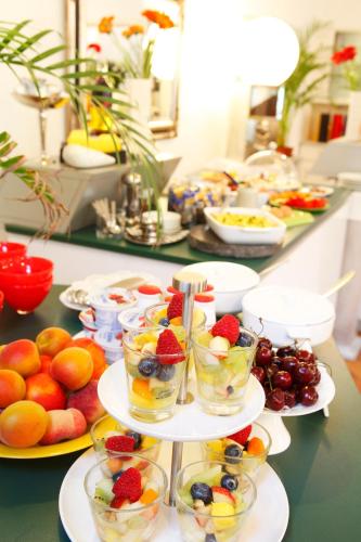 a buffet with plates of fruit and bowls of food at Hotel Kleiner König in Schwangau