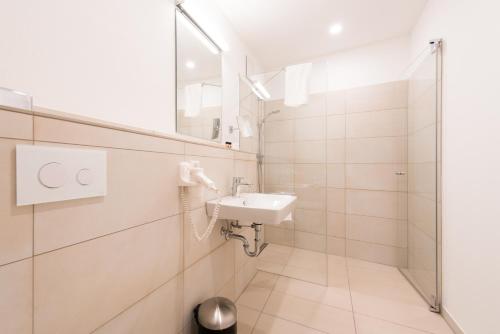 a bathroom with a sink and a mirror at Hotel & Gasthaus Löwen in Waldkirch