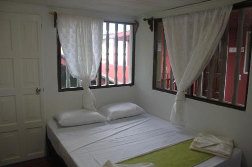 a bedroom with a bed with curtains and a window at El Caite Hostel in Granada