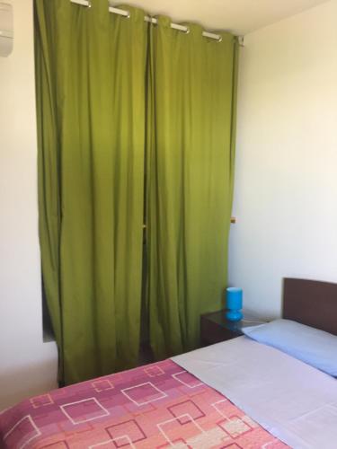 マルツァメミにあるCasa Mareaのベッドルーム(緑のカーテン、ベッド付)